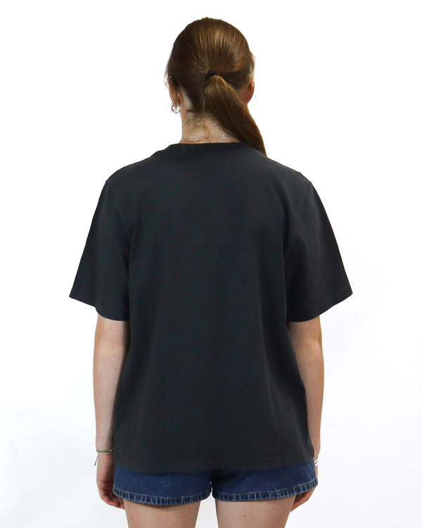 Back view of a black oversized t-shirt with a relaxed fit, paired with high-waisted denim shorts for a casual style.