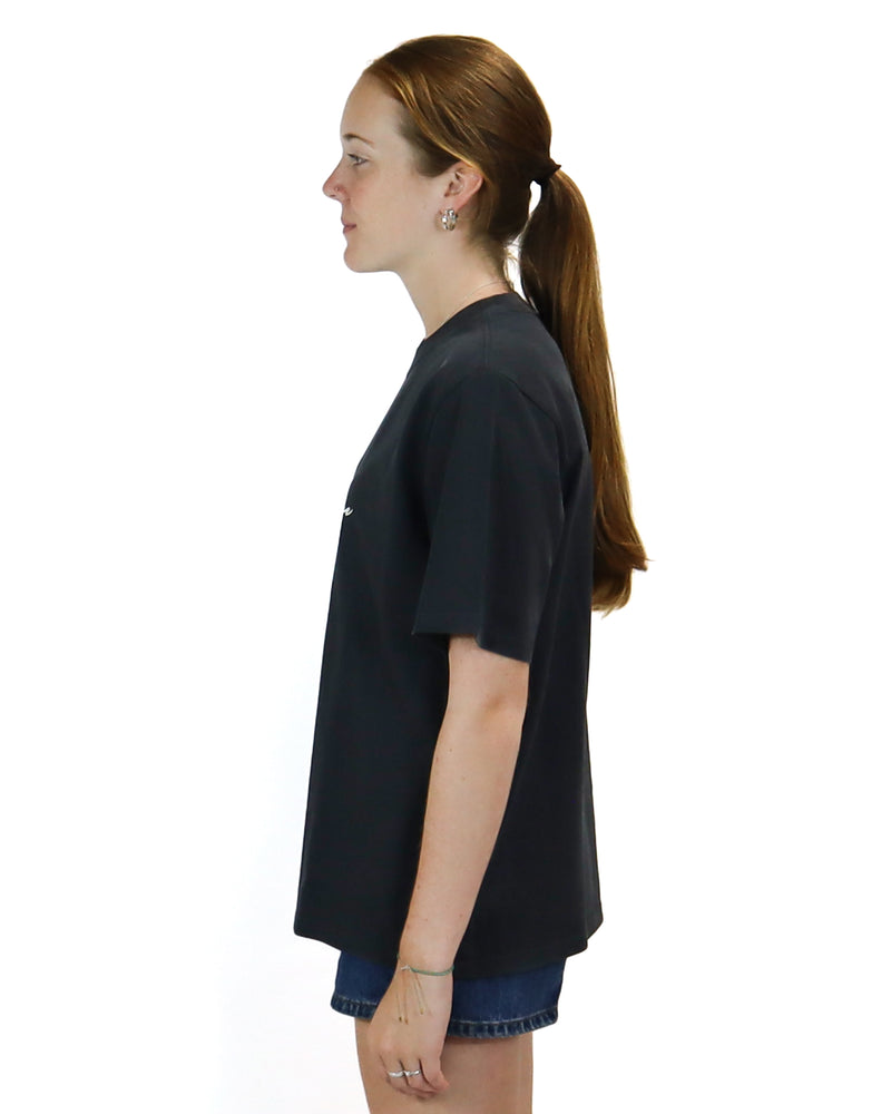 Side view of a black oversized t-shirt with a relaxed fit, paired with high-waisted denim shorts for a casual look.