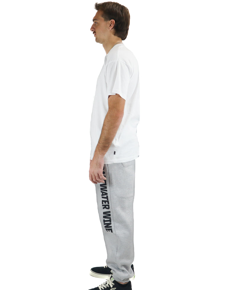 Side view of grey trackpants featuring Saltwater Wine branding along the leg