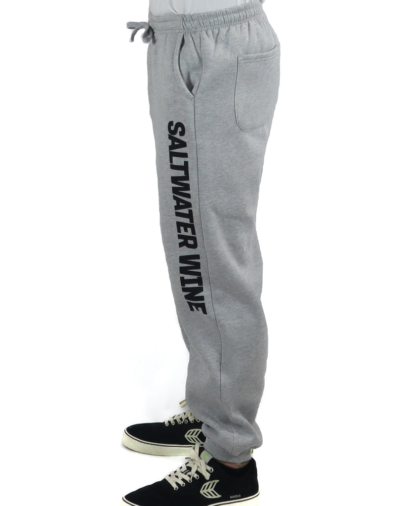 Close-up of grey trackpants with bold black Saltwater Wine logo down the left leg
