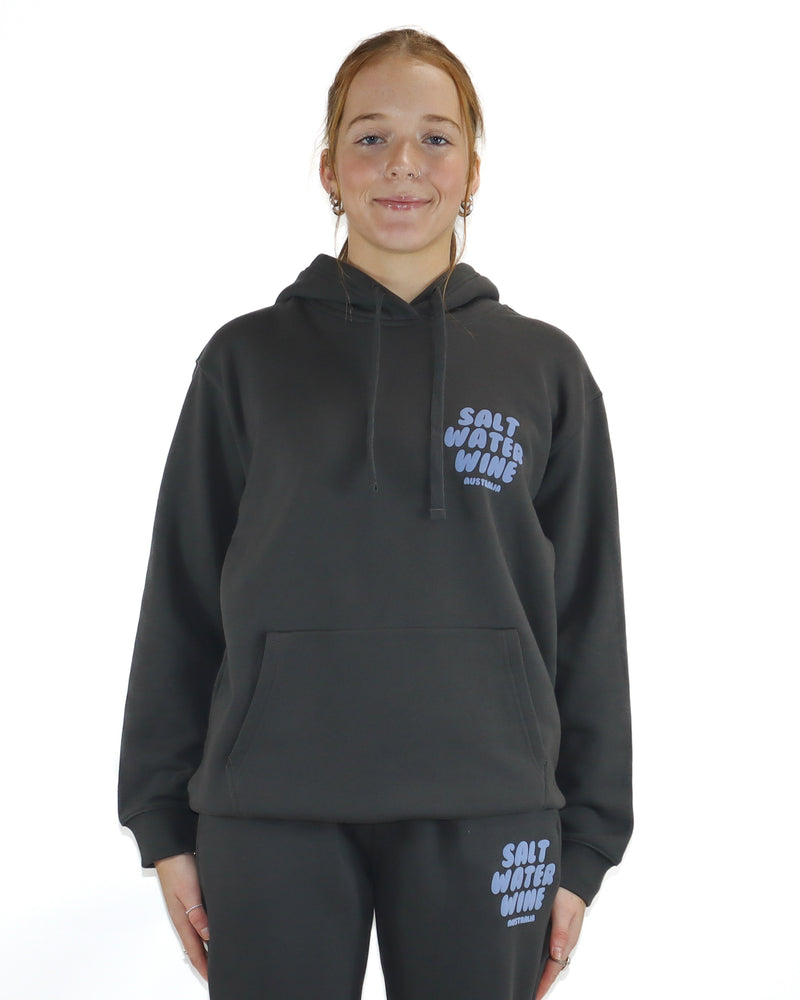 Person wearing a dark gray hoodie and pants with 'Salt Water Wine' branding on a white background