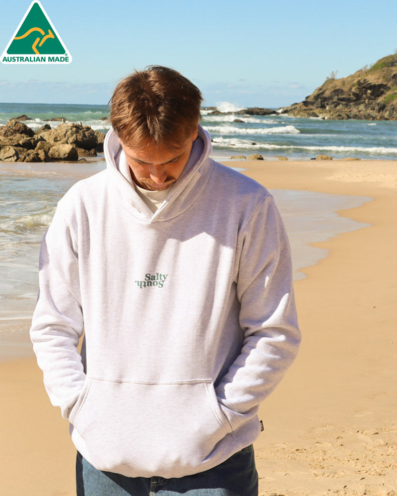 Light grey Salty South hoodie with teal upside-down chest logo, photographed at the beach