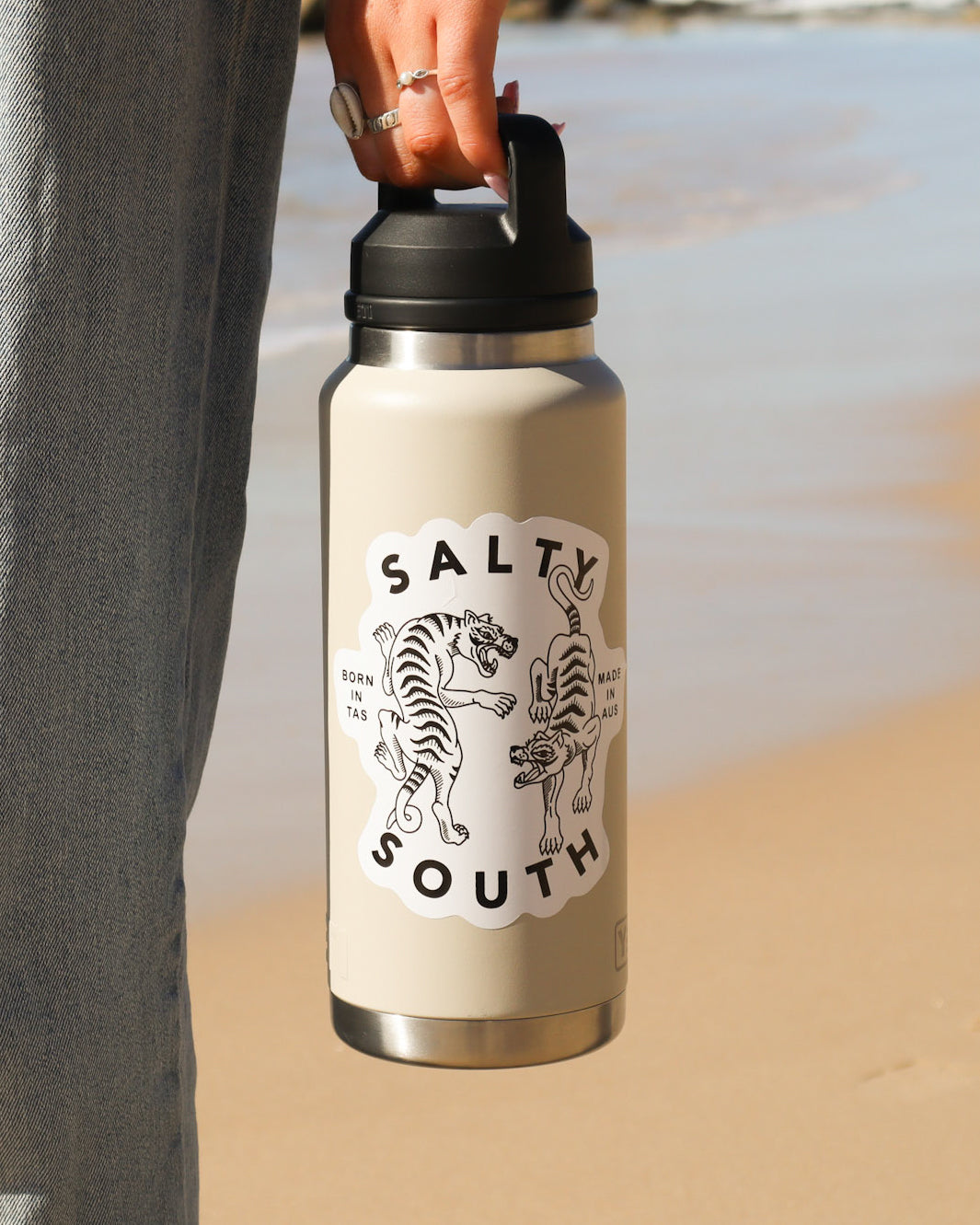 Salty South insulated drink bottle in cream with black lid, featuring tiger graphic and ‘Born in TAS, Made in AUS’ text.
