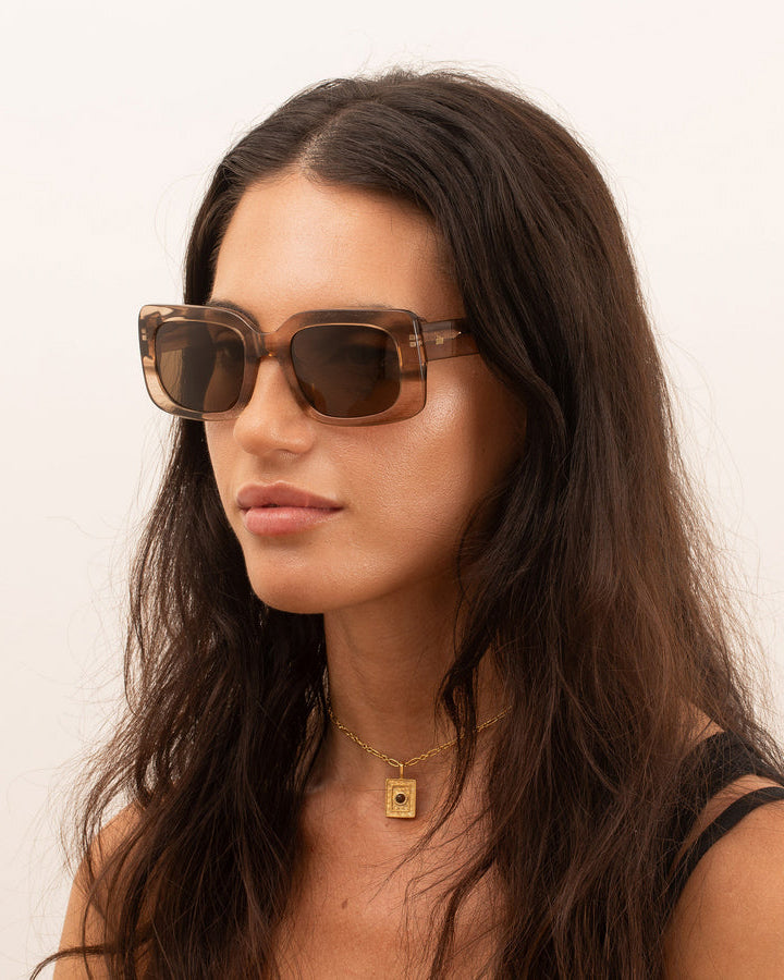 Angled view of the woman wearing a sunglasses, showing the side profile of the frame and how it sits on the face.