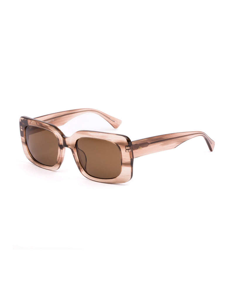 Side-angled view of the a rectangular sunglasses, highlighting the thick temples and translucent blush-toned frame.