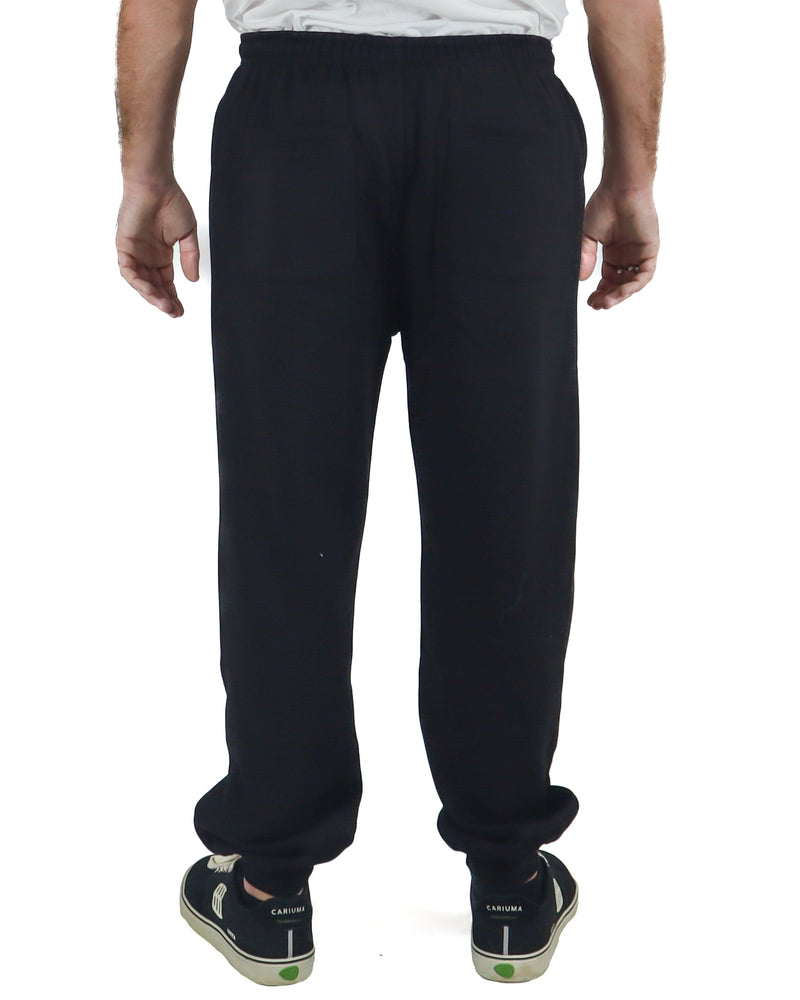 Back view of men's black fleece trackpants with elastic waistband and relaxed fit