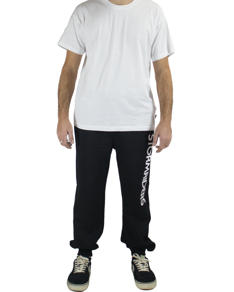 Men's black trackpants with Stormriders logo on leg, paired with white tee and sneakers, front view