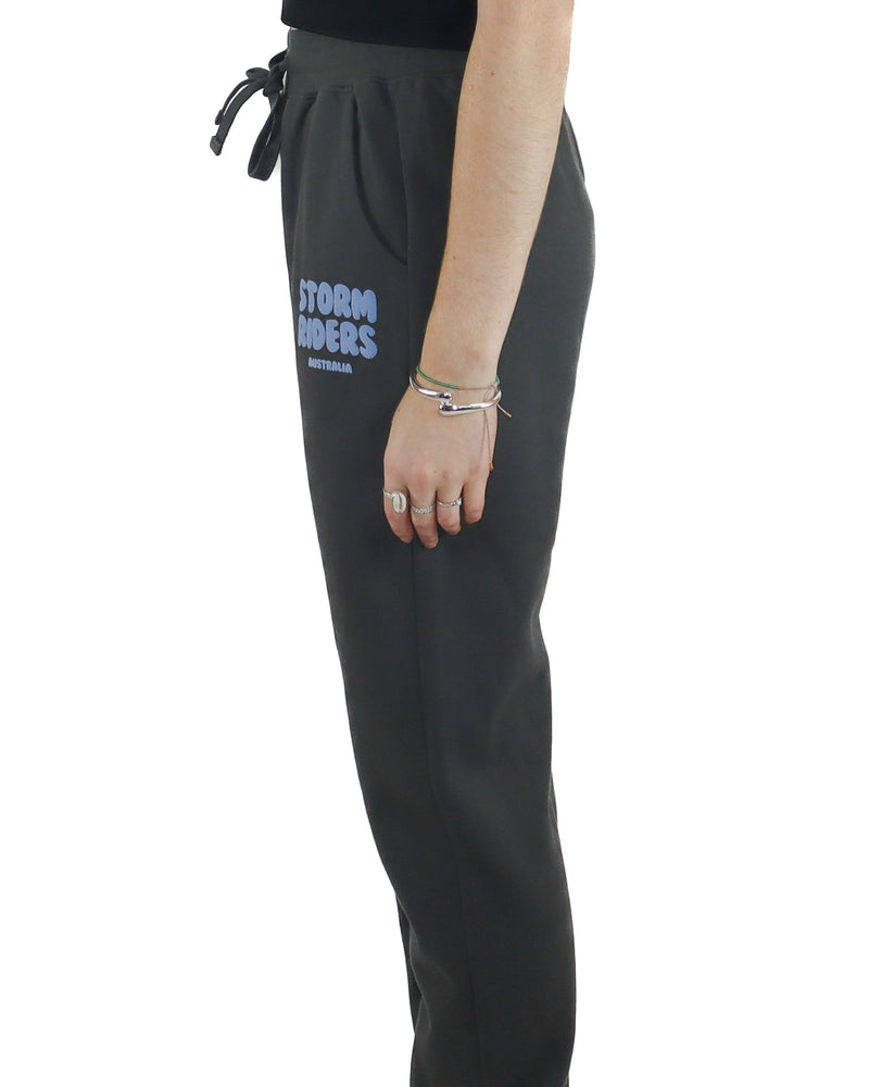 Side view of charcoal Storm Riders track pants with blue logo detail.