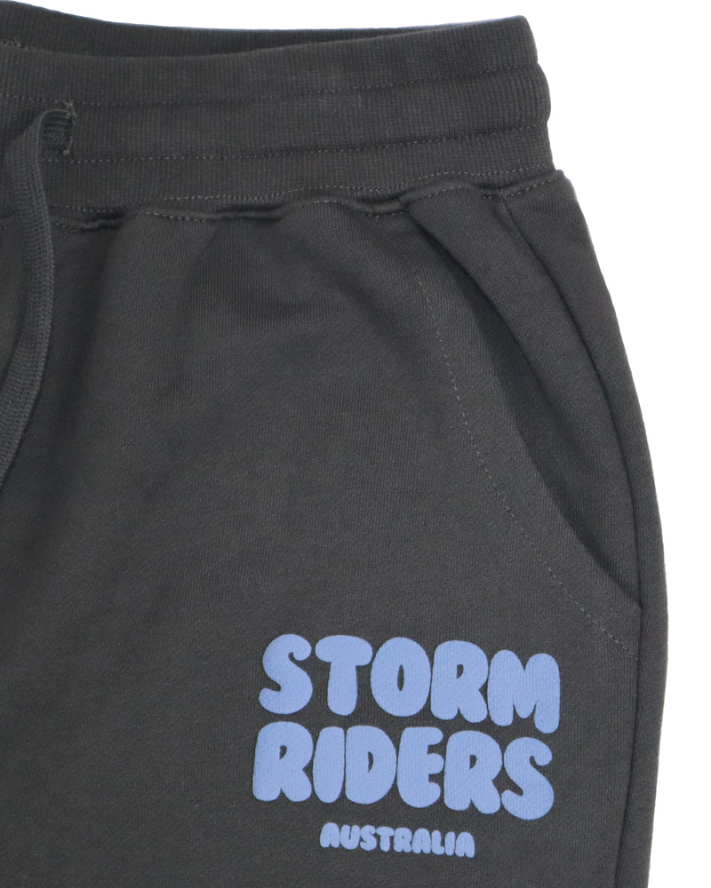 Close-up of blue Storm Riders Australia logo on charcoal track pants.