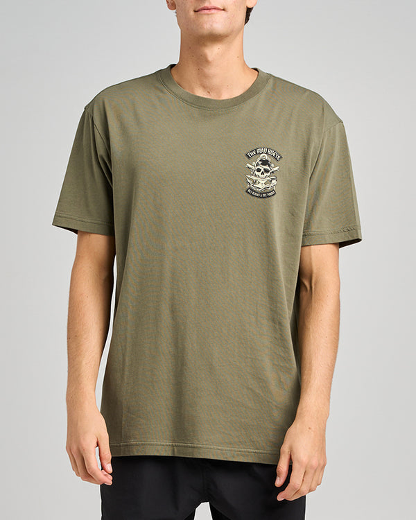 A model wearing an olive green graphic t-shirt with a skull design and the text on the chest.