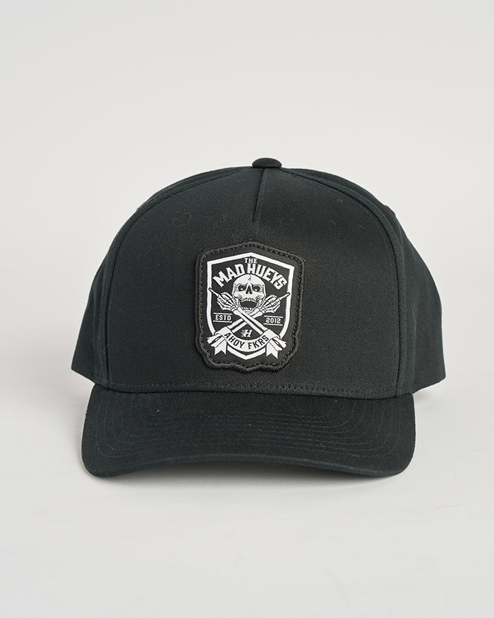 A black baseball cap featuring a front patch with the "Mad Hueys" logo, crossed anchors, and bold white text detailing design.