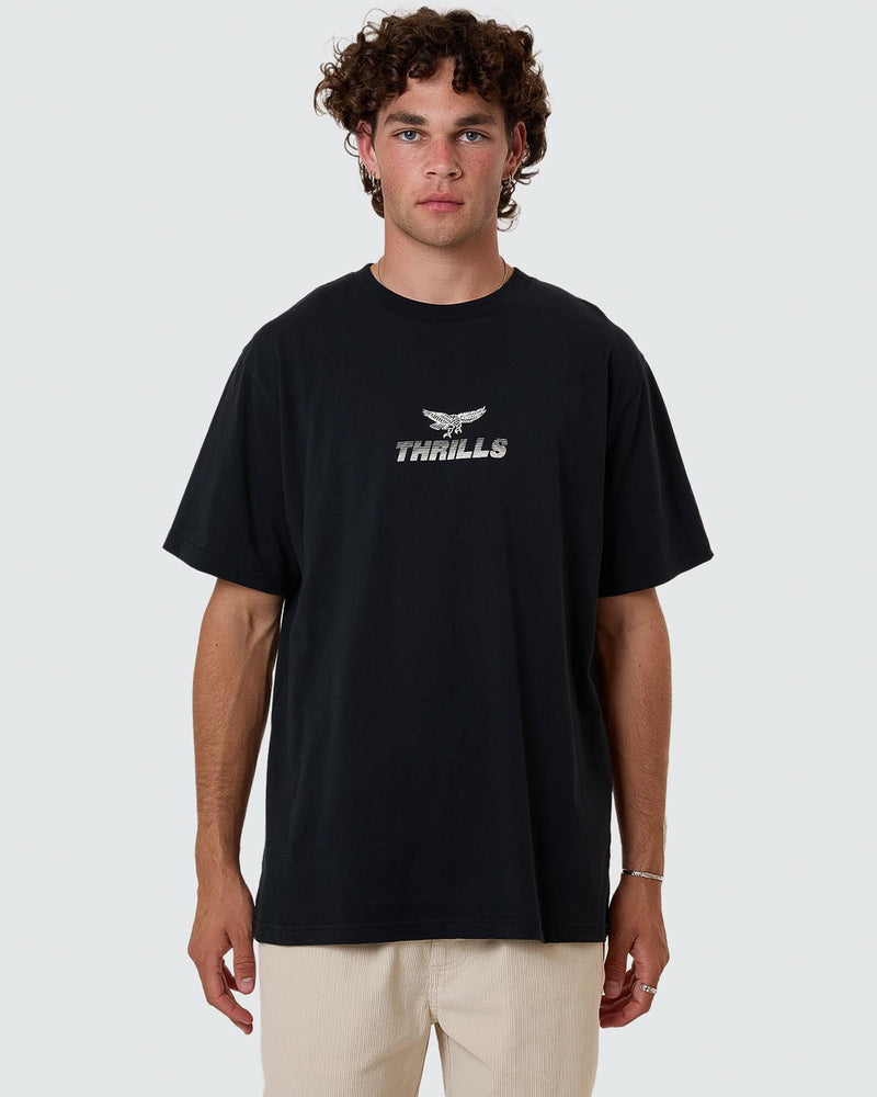 Model wearing black Thrills t-shirt with eagle logo and text graphic on chest, short sleeves and crew neck