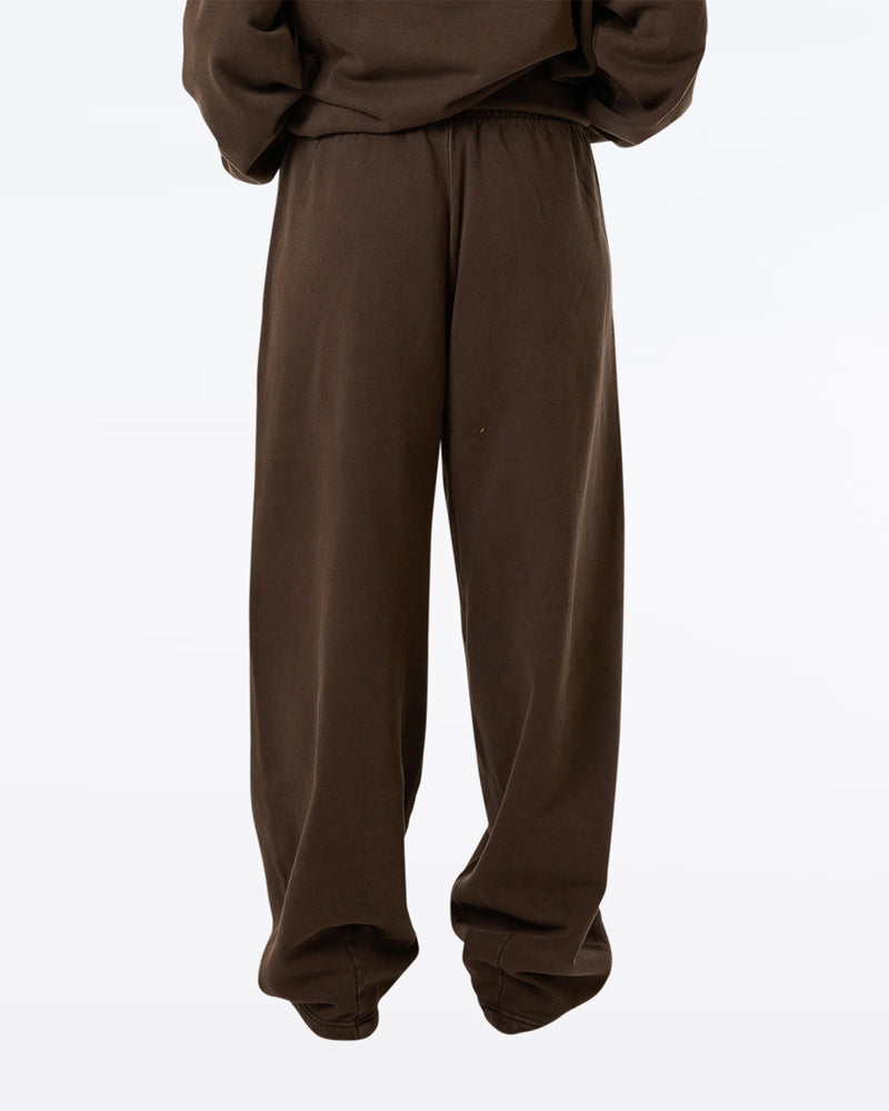 Back view of brown Thrills wide-leg sweatpants with elastic waistband, worn by a model with matching oversized hoodie.