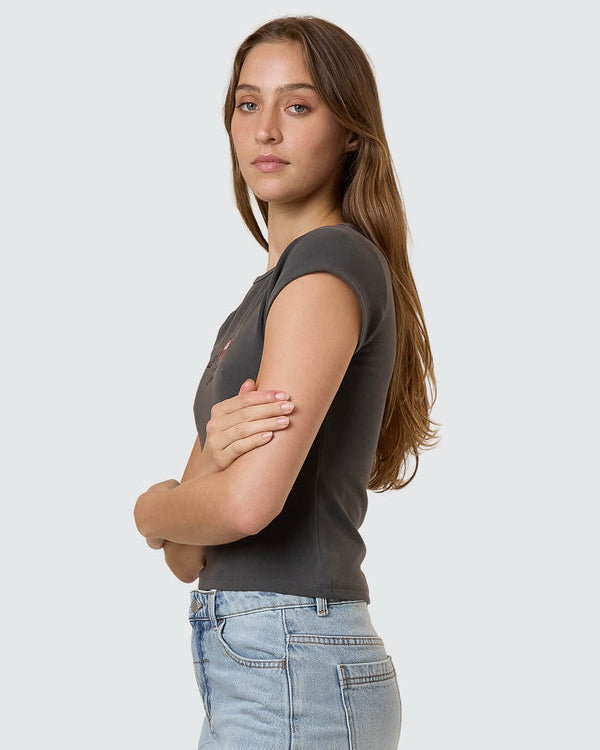 Side view of fitted black graphic tee and light wash denim mini skirt