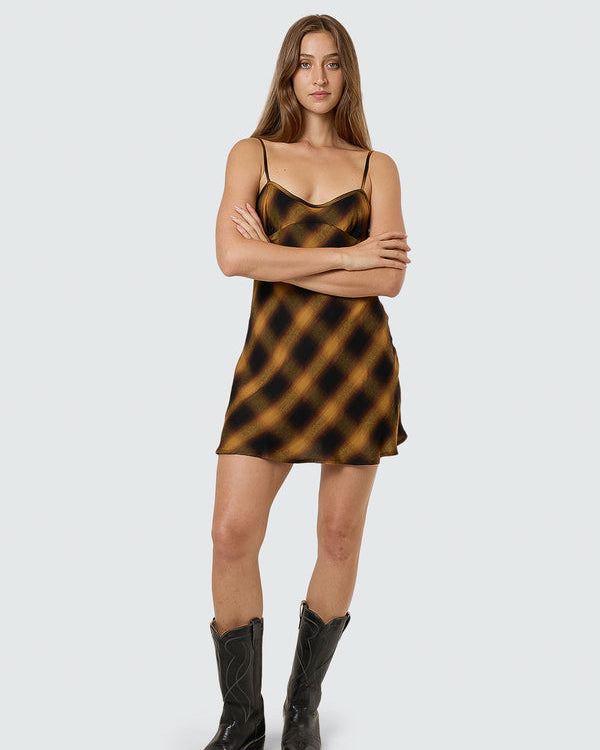 Brown and black check satin slip dress with thin straps and relaxed fit.