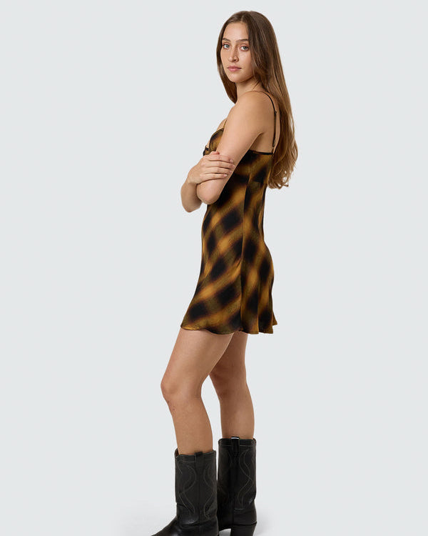 Side view of brown and black check satin slip dress with thin straps.