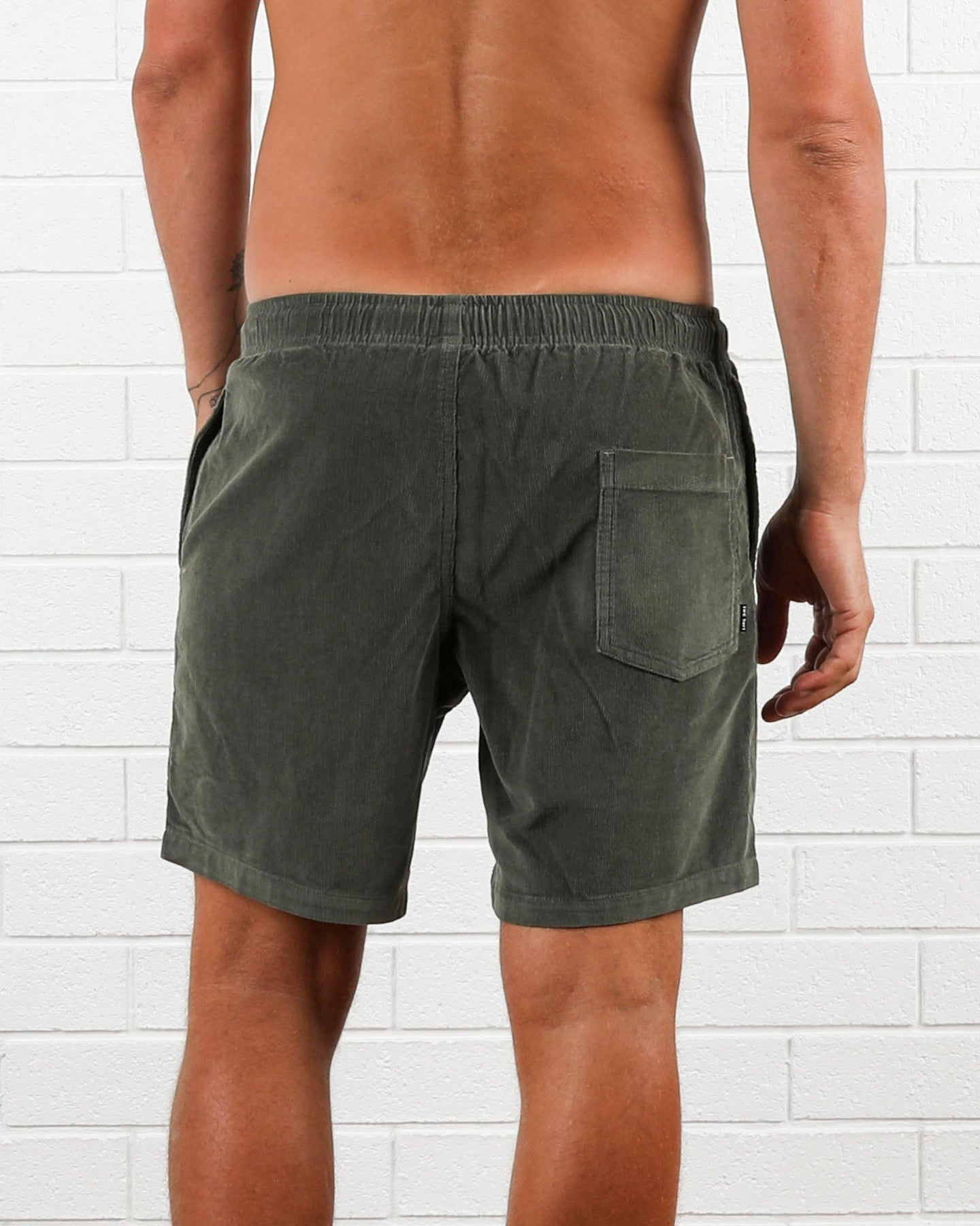 Back view of olive green cord shorts with single patch pocket