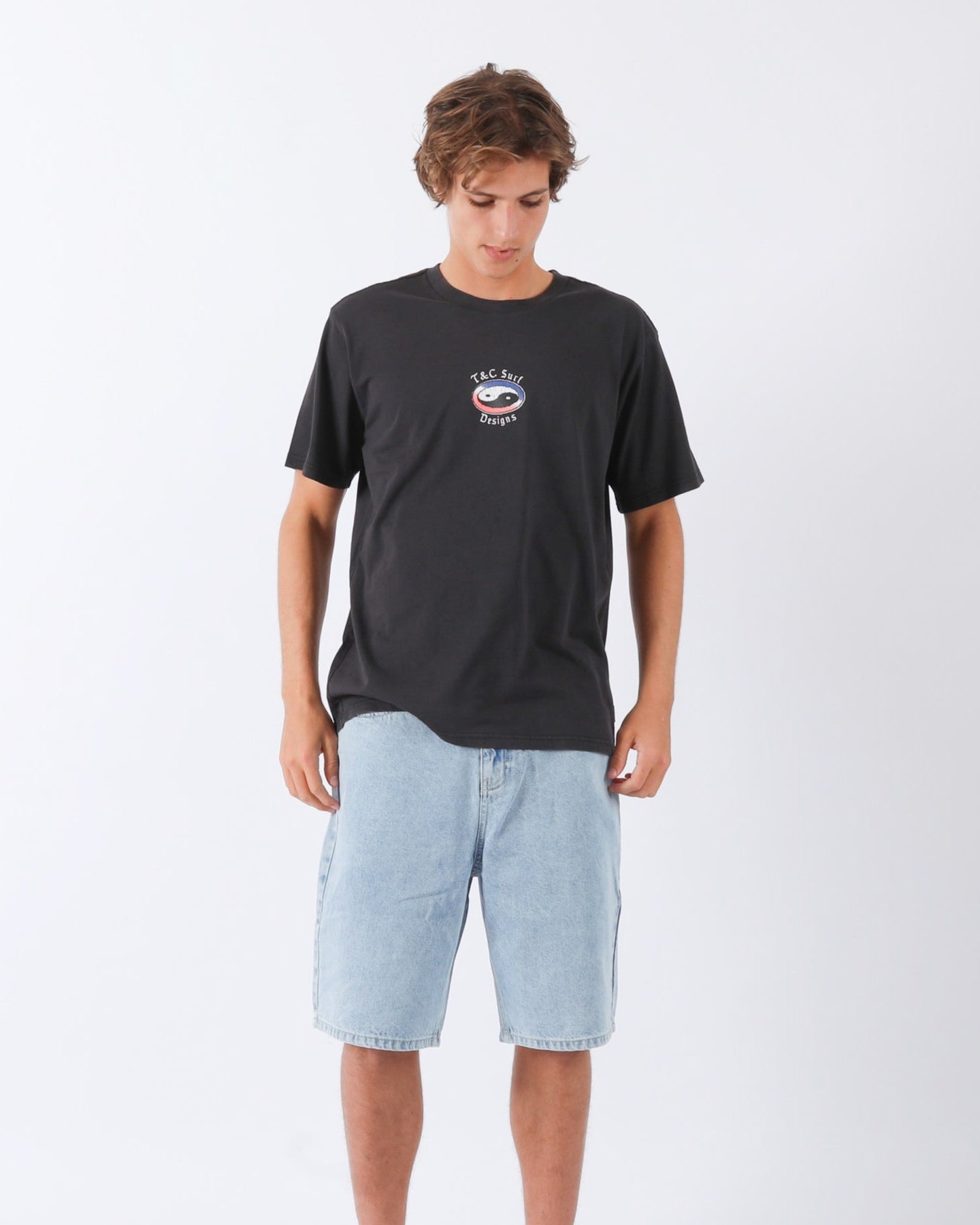 Model wearing black tee with light blue denim shorts for a casual look