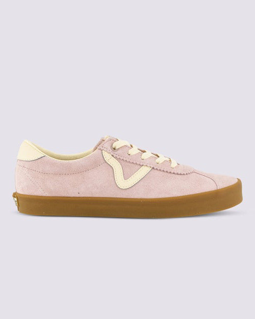 Side view of a low-top sneaker featuring light pink suede upper, cream detailing, and a brown gum sole.
