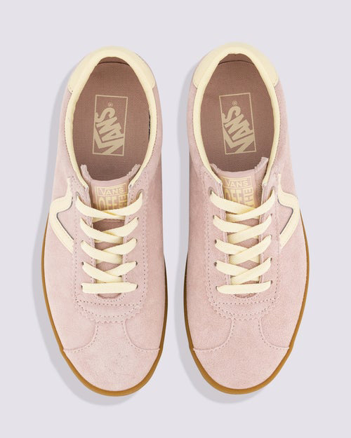 Top view of a pair of Vans sneakers featuring light pink suede uppers, cream laces and linings, gum soles, and Vans branding on the insoles.
