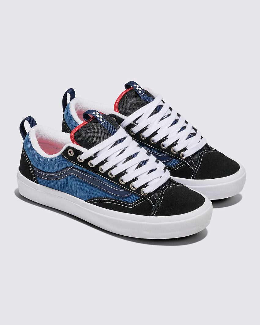 Pair of Vans sneakers in blue and black with white laces, suede and canvas upper, and a white rubber sole on a grey background.