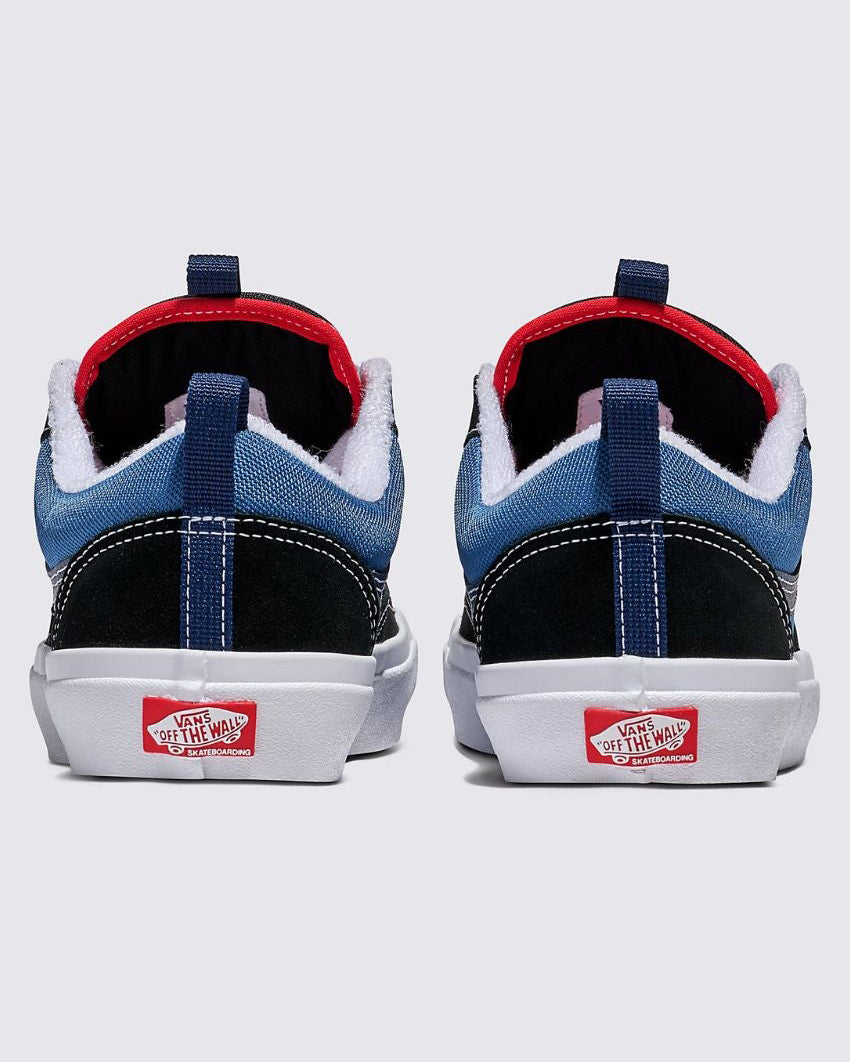 Back view of Vans sneakers in blue and black with red accents, white fluffy lining, and 'Off The Wall' logo on the heel.