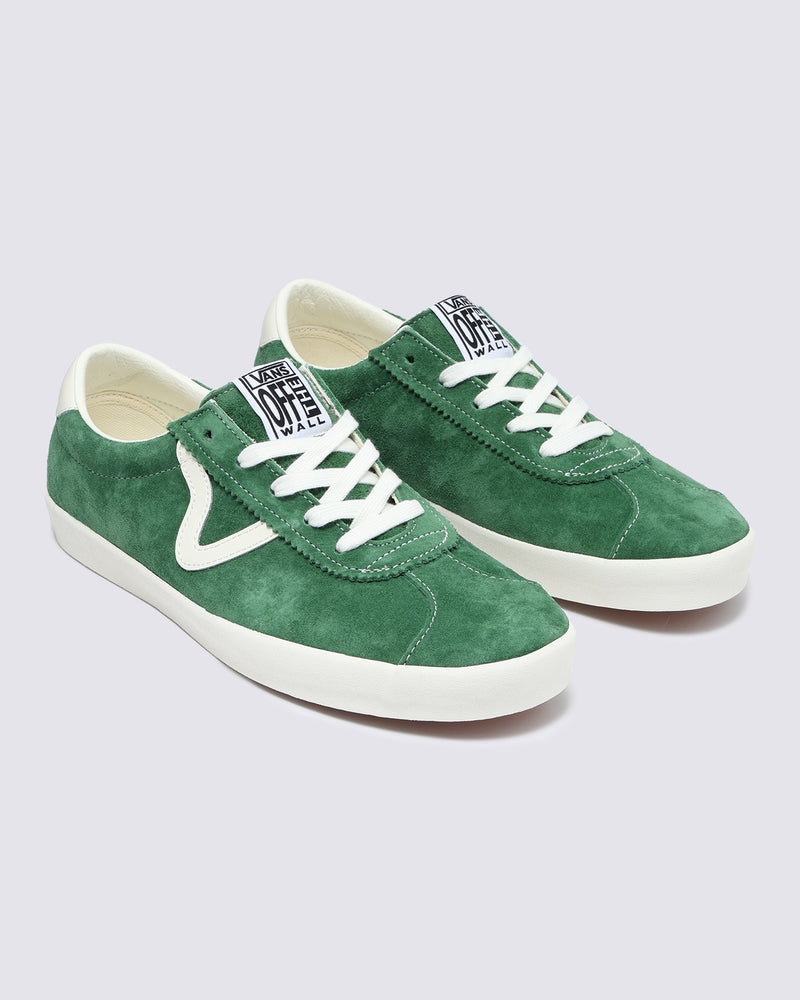 Pair of green suede Vans sneakers with white accents, wavy side stripe, white laces, and 'Off The Wall' tongue logo.