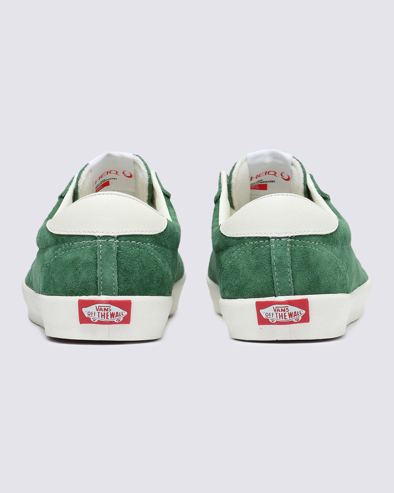 Rear view of green suede Vans sneakers with white heel accents and red 'Off The Wall' logo on the rubber sole.