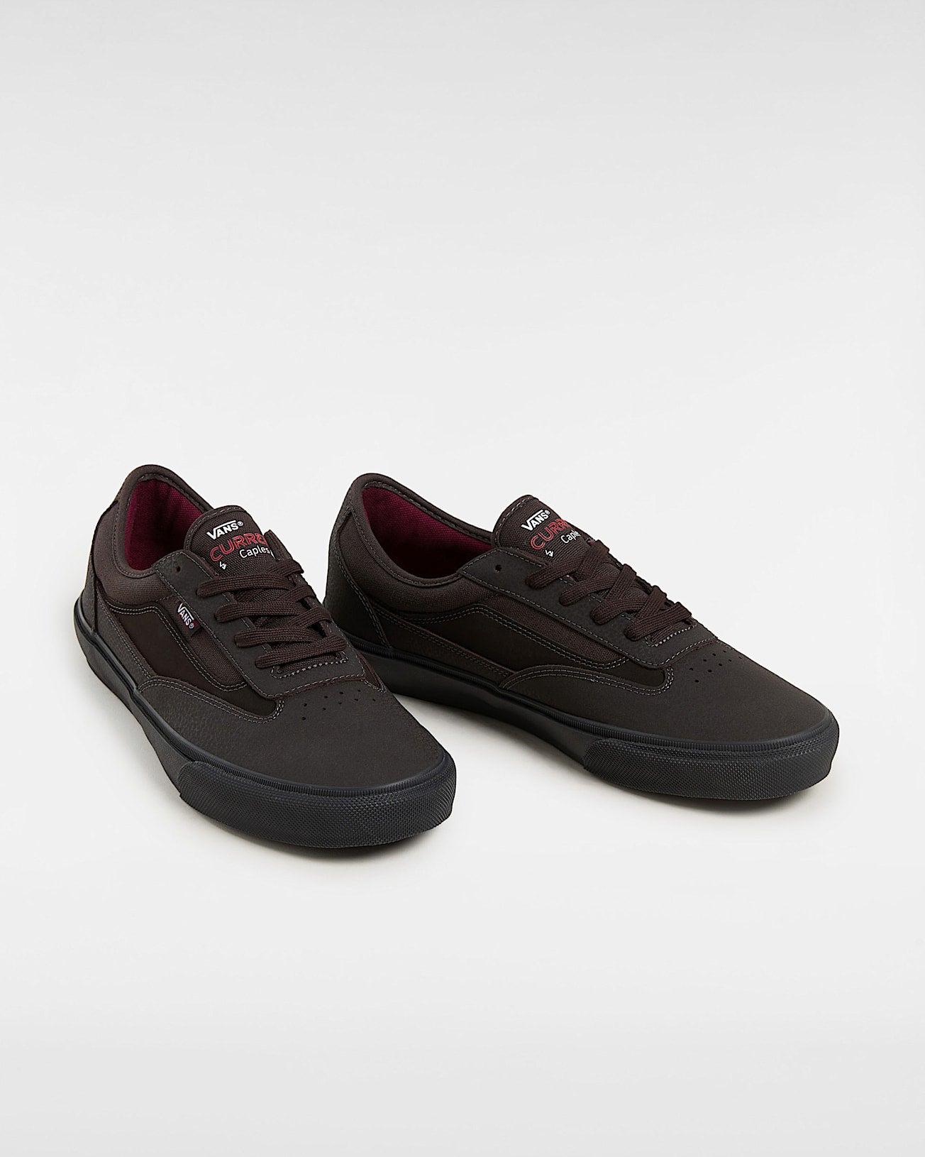 Pair of Vans brown skate shoes with black soles, burgundy lining and stitched panel detail.