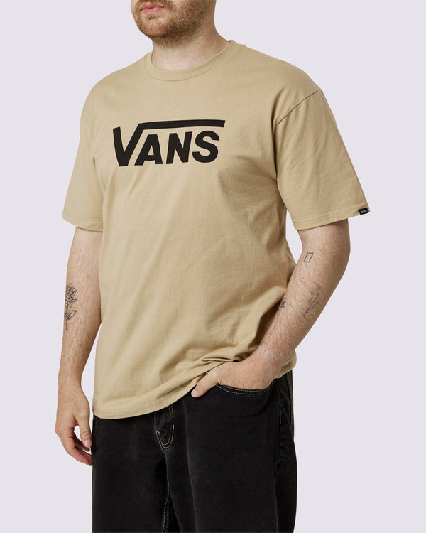 Man wearing a beige Vans t-shirt with bold black Vans logo on the chest, paired with black pants, for casual and relaxed fit.