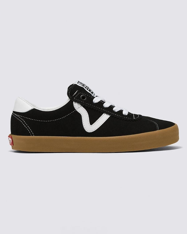 A side view of black low-top sneakers with white accents, a wavy stripe design, white laces, and a gum rubber sole.