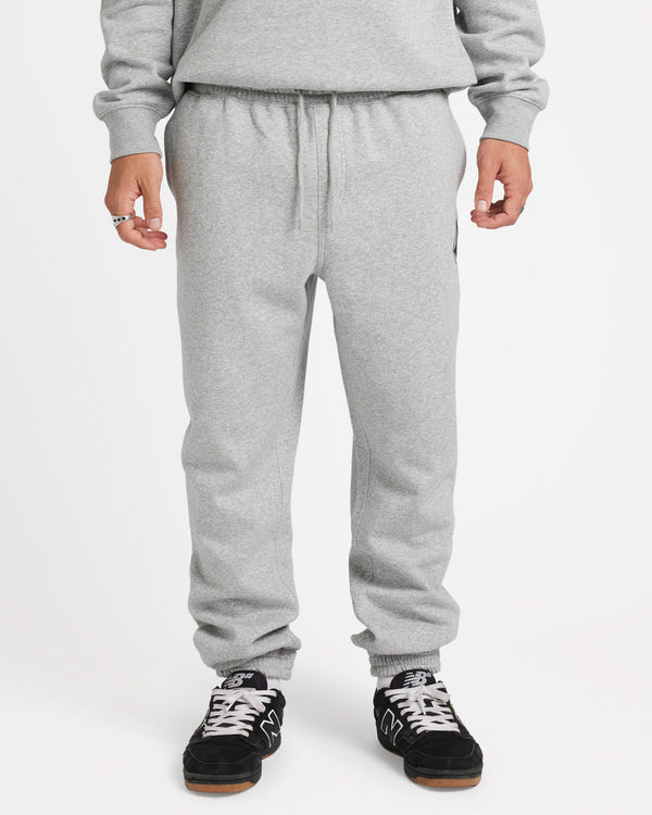 Model wearing light grey sweatpants with an elastic waistband and cuffs, paired with black and white sneakers.