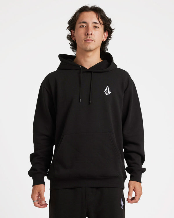 Model wearing a black Volcom hoodie with a small white logo on the chest, drawstring hood, and front kangaroo pocket.