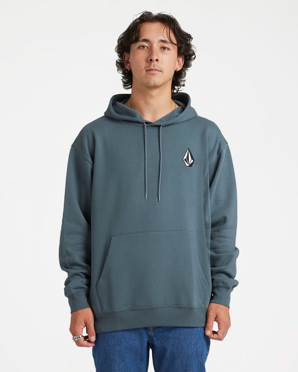 Male model wearing a blue-grey Volcom hoodie with a small logo on the chest, front pocket, drawstrings, and blue jeans.