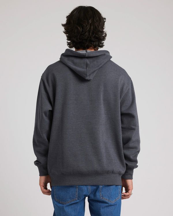 Back view of a male model wearing a dark grey Volcom hoodie with a hood down, paired with blue jeans, against a plain backdrop.