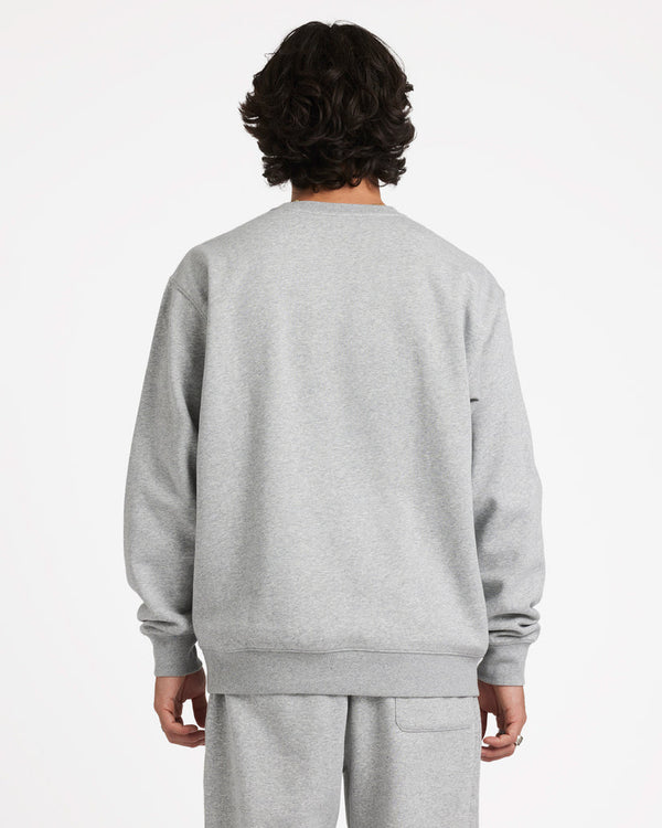 Back view of a male model wearing a light grey crewneck sweatshirt with matching sweatpants, showing a relaxed fit design.