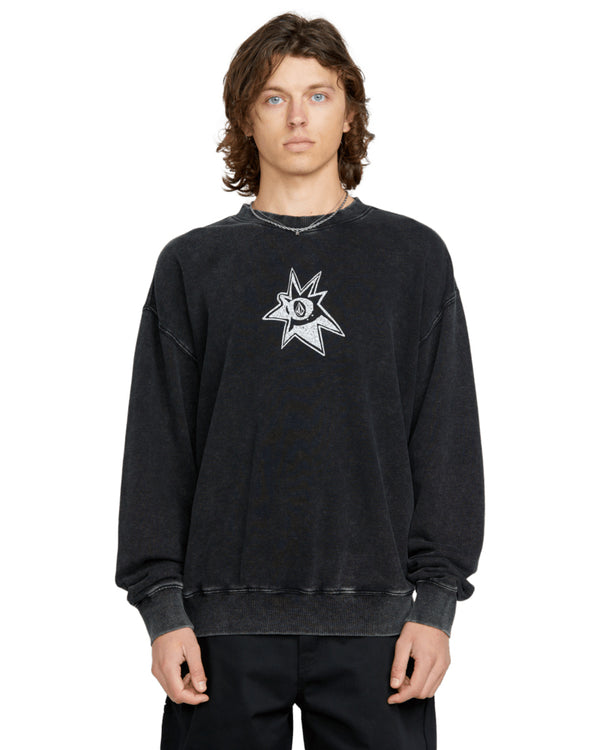 Male model wearing a black vintage-wash Volcom crewneck sweatshirt with a distressed logo graphic on the chest.