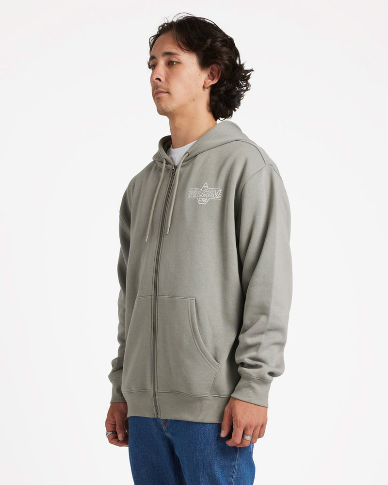 Side view of a model wearing a light grey Volcom zip-up hoodie with a small white logo on the chest and front pockets.