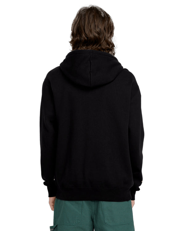 Back view of a black Volcom zip-up hoodie with a relaxed fit, featuring a hood and ribbed cuffs, worn by a model in green pants