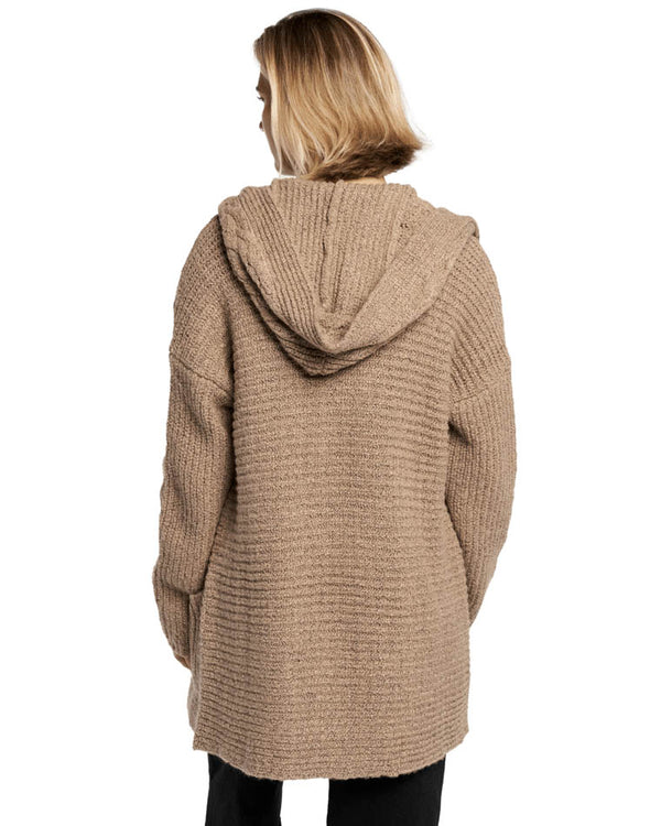 Back view of a model wearing a brown oversized knit cardigan with a hood, featuring a textured ribbed pattern.