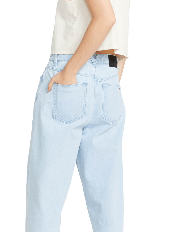 Close-up back view of light blue high-waisted jeans featuring back pockets, a black patch detail, and a relaxed straight-leg fit.