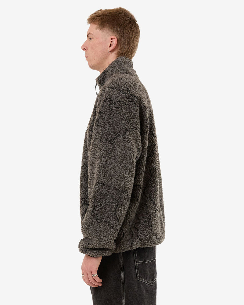 Side view of a men's dark grey sherpa fleece pullover featuring a subtle camouflage pattern and a high collar for added warmth.