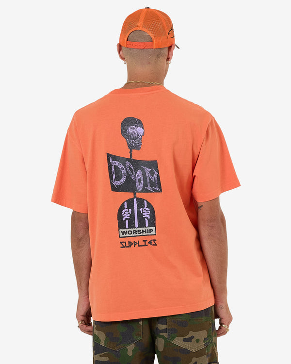 Back view of orange graphic tee with large skull and text print
