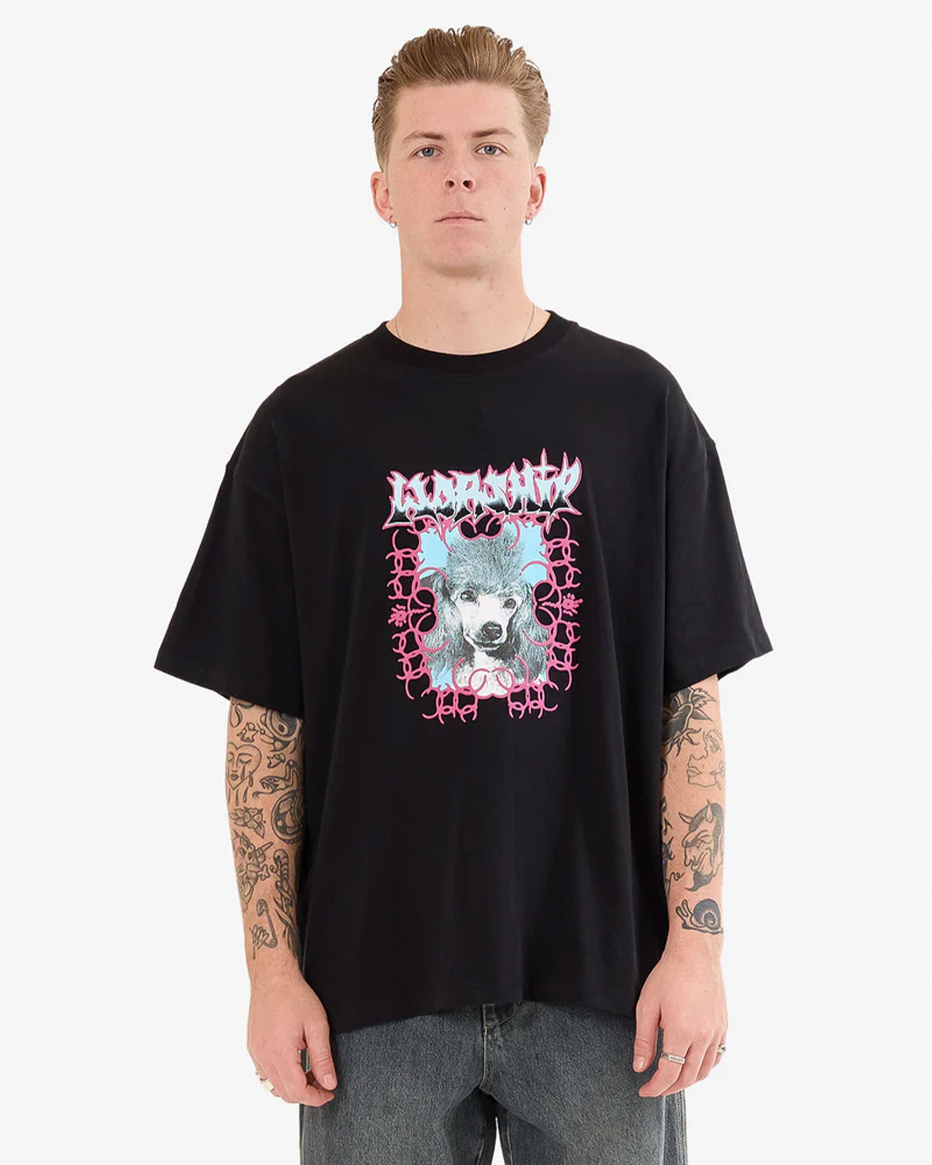 Black graphic tee with pink and blue dog print on front, worn by male model
