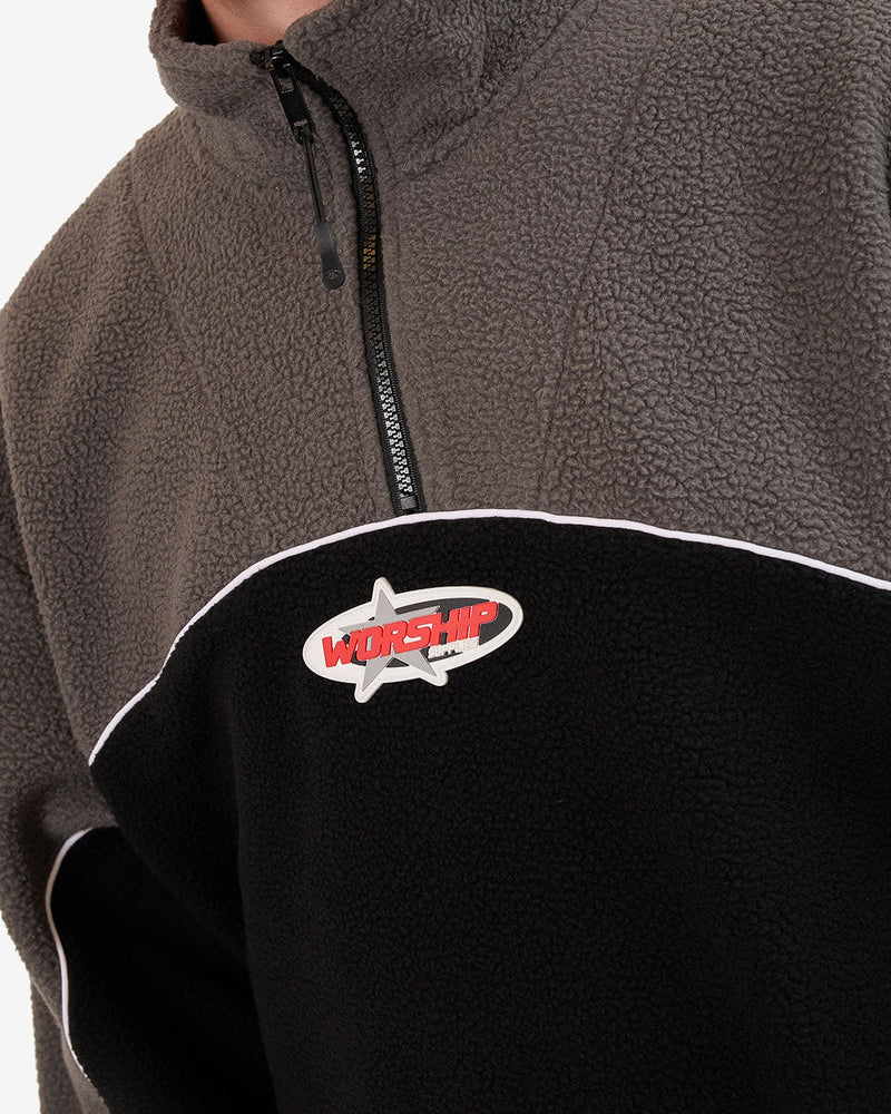 Close-up of the Worship fleece featuring textured grey fabric, white piping, and embroidered Worship logo on the chest.