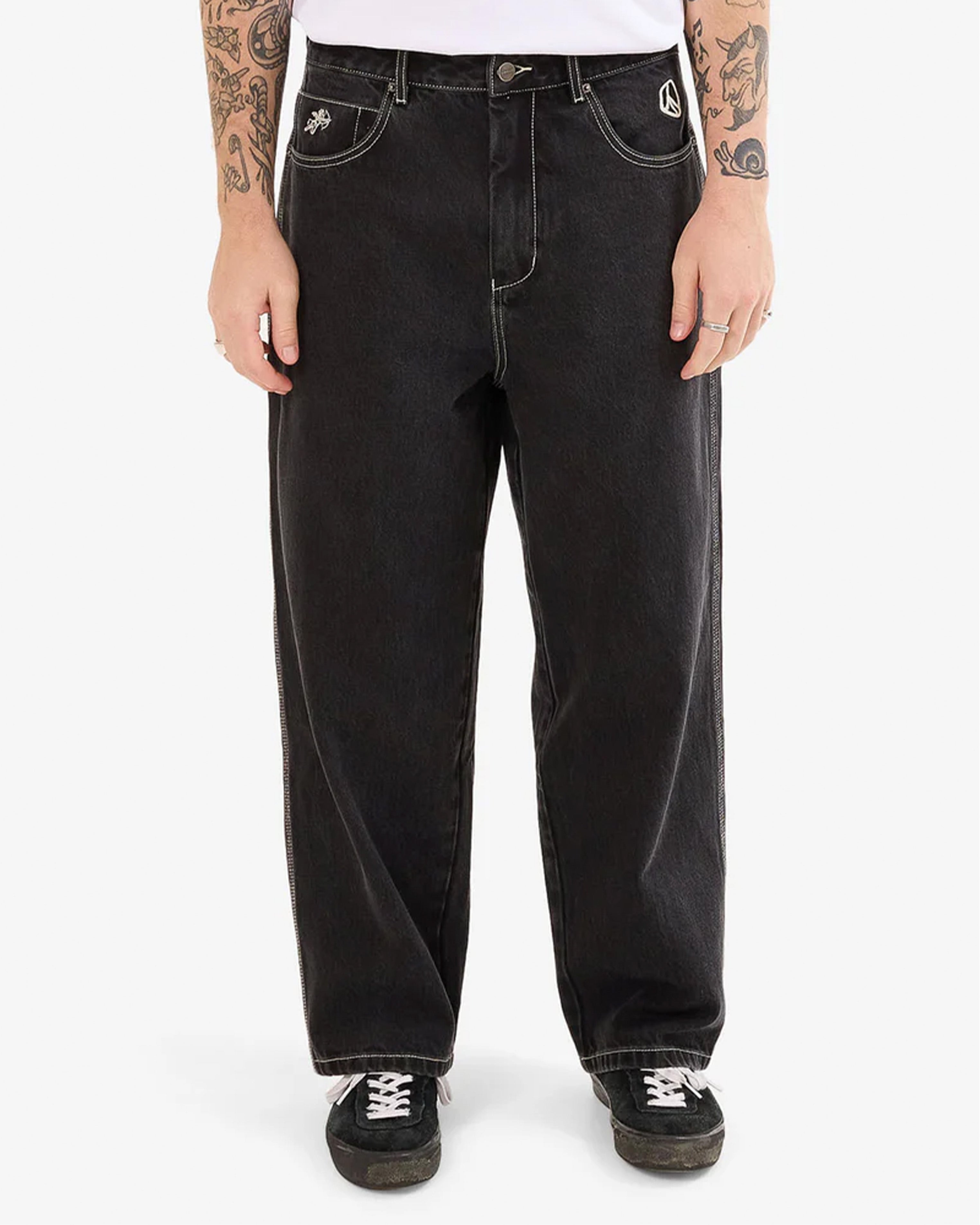 Front view of men's black wide-leg jeans with contrast white stitching.