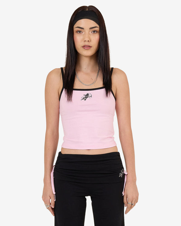 Pink cropped tank top with black straps and "Worship" logo, paired with black drawstring pants with embroidered design.