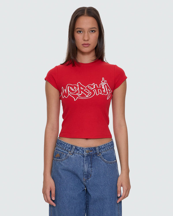 Red cropped t-shirt with white "Worship" graphic design on the front, paired with high-waisted denim jeans.