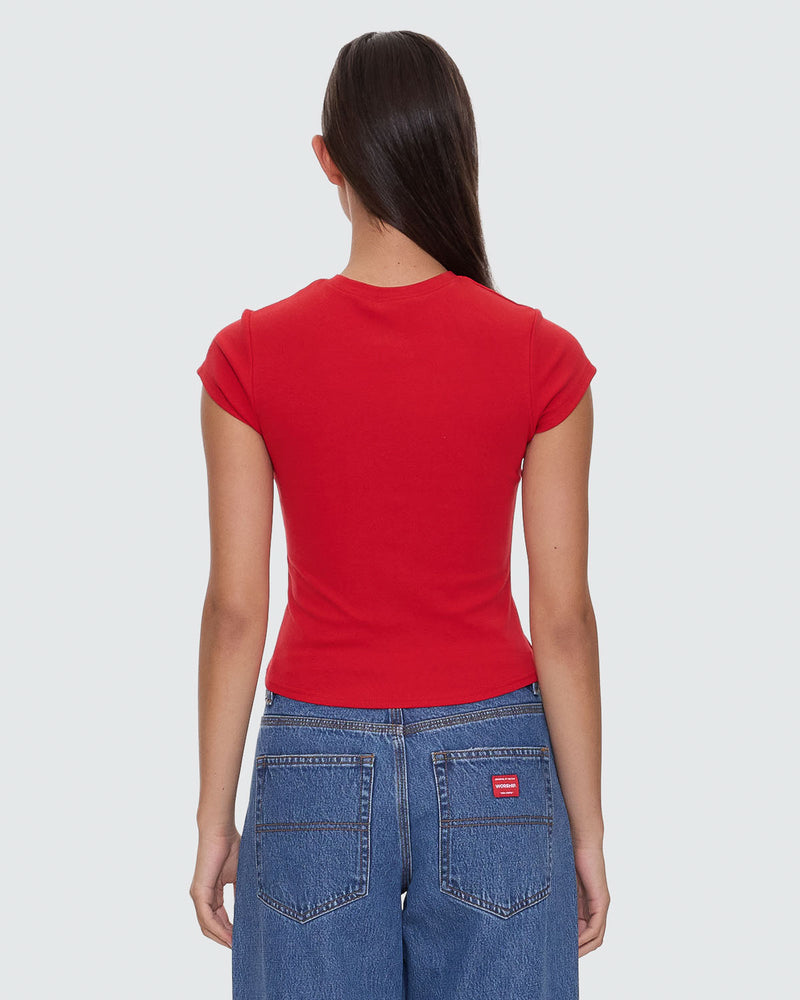 Back view of red cropped t-shirt with white "Worship" graphic, worn with high-waisted denim jeans.
