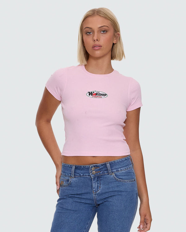 Light pink fitted crop tee with Worship graphic on chest and blue high waisted jeans